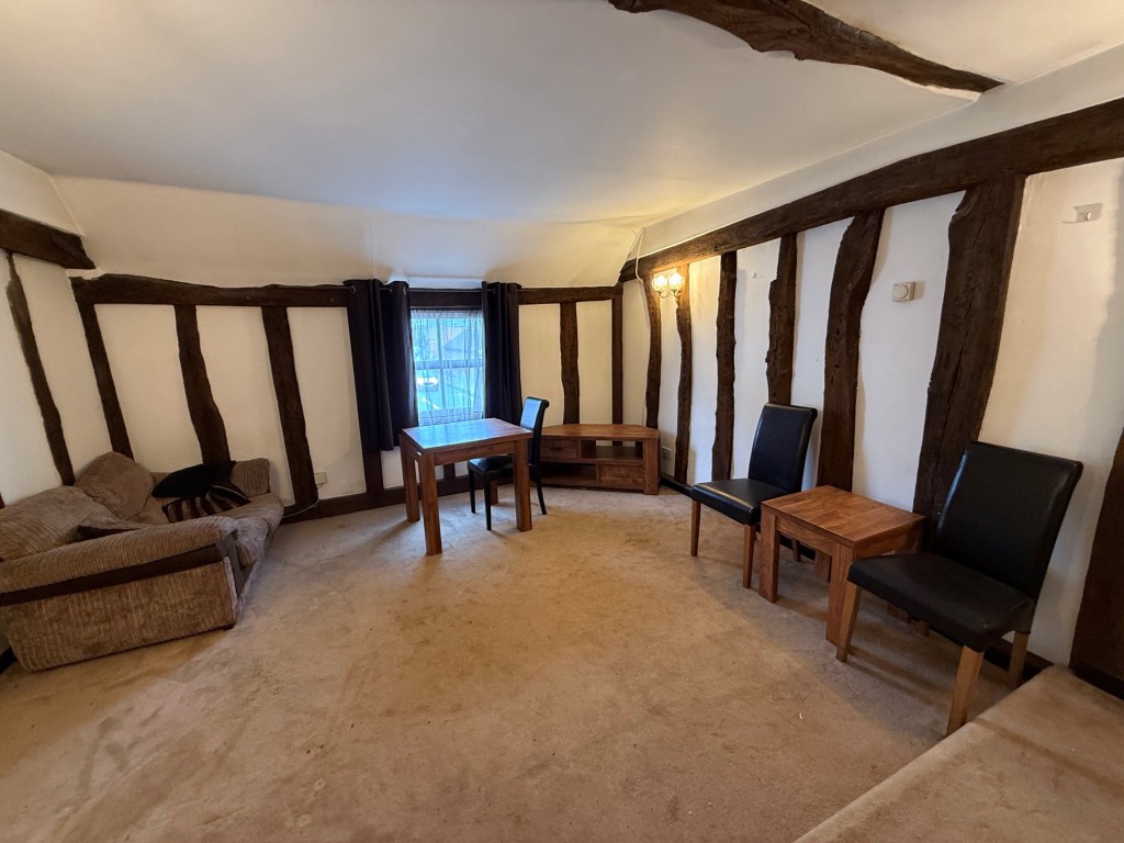 Lot: 69 - RESTAURANT PREMISES IN MALDON HIGH STREET WITH TWO BEDROOM FLAT ABOVE - Alternative view of the living room with exposed beams and studwork